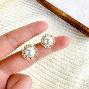French vintage pearl and zircon stud earrings with gold finish shown on finger