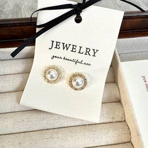 Detail view of French vintage pearl stud earrings with zircon halo on jewelry card