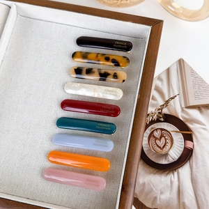 Detailed set of 9 acetate hair clips with golden France Handmade lettering in warm scene