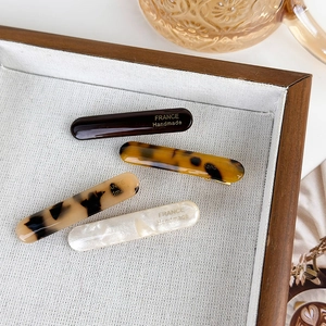 Detailed macro view of four acetate hair clips with France Handmade gold lettering