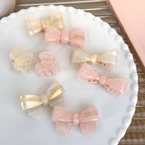 8-piece cute acetate hair clip set with cream and pink bows on a decorative pearl tray