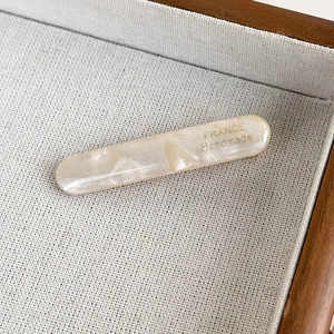 Detailed macro view of acetate hair clip with golden France Handmade engraving