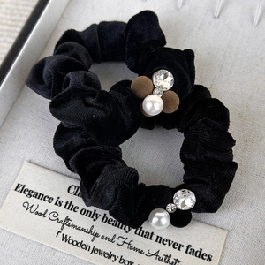 Elegant black velvet hair scrunchies with white pearls and plush ball in a display box