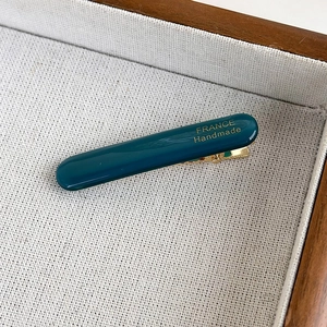 Macro shot of dark green acetate hair clip with gold France Handmade lettering