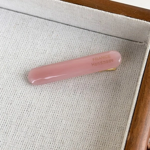 Detailed macro view of pink acetate hair clip with gold France Handmade lettering