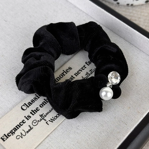 Close-up of velvet hair tie featuring elegant pearls and sparkling crystal charms