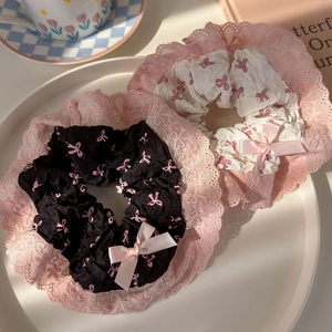 Pink bow print scrunchies with lace trim set in black and white styles on a plate