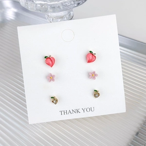 Pink cherry and flower stud earrings set with gold peach accents on a white jewelry card