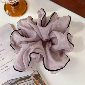 Detailed view of oversized chiffon hair scrunchie in light purple with black contrast edges