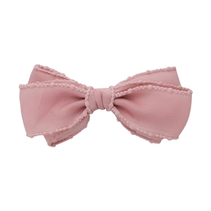 Barrette à cheveux rose avec triple nœud en tissu et bordure perlée sur fond blanc