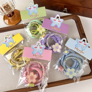 Detail of colorful elastic hair bands with flower charms and beads on display tray
