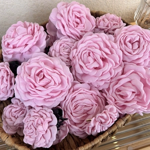 Elegant rose pink fabric flower hair claw clips set in a rustic basket display