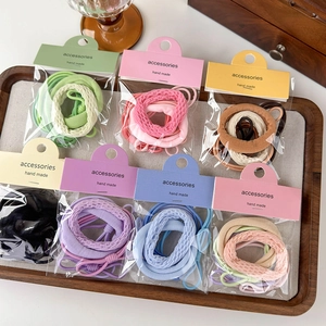 Dettaglio di set di elastici per capelli colorati in confezioni su vassoio