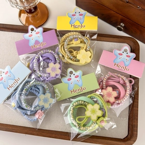 Set of 5 candy-colored flower hair ties on a wooden tray showing diverse elastic bands