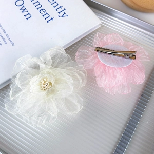 Detalle de pinzas para el cabello con flores de organza en blanco crema y rosa suave metálicas
