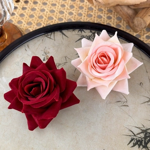 Detailed view of artificial flocked red and pink rose clips on a bamboo tray