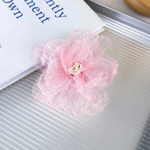 Detalle de pinza para el pelo con flor de organza rosa y perlas en bandeja plateada