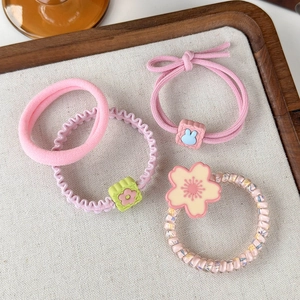 Close-up of pink hair ties set featuring floral patterns and cute rabbit charms