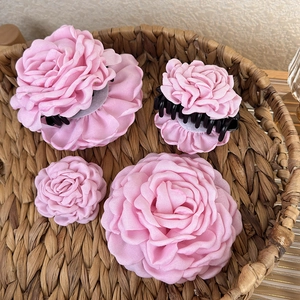 Pink chiffon rose hair claw clips and flower accessories in a rustic basket