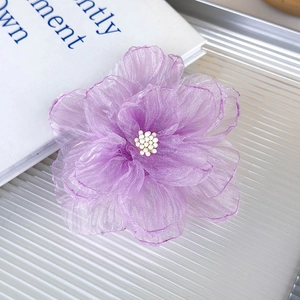 Vista macro de la pinza para el pelo con flor de organza púrpura y perlas finas