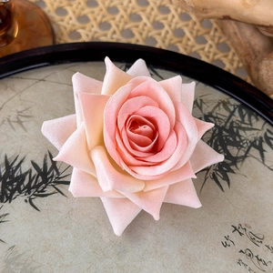 Macro detail of artificial velvet rose hair clip with realistic pink gradient petals