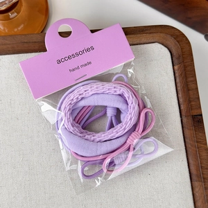 Dettaglio del set di elastici per capelli viola sfumati con fiocchi eleganti