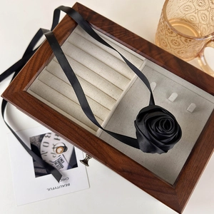 French vintage black satin rose flower choker necklace on a wooden jewelry display