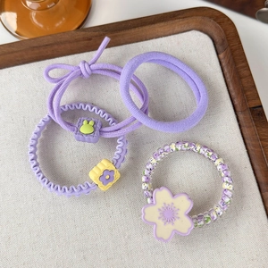 Detail view of purple floral hair ring set with resin bunny and flower charms
