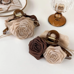 Elegant vintage fabric rose hair claw clip in champagne and brown on a white background
