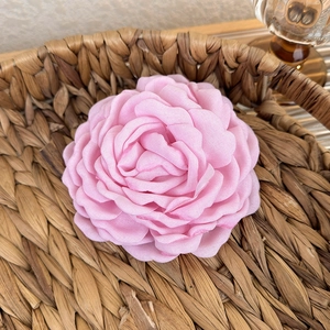 Detail of elegant pink fabric rose hair claw with delicate layered petal textures