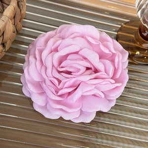 Detail of elegant pink fabric rose hair claw clip with multi-layered textile petals