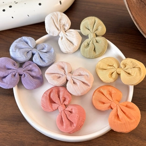 Lot de huit barrettes à nœuds colorées pour filles présentées sur un plateau blanc