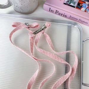 Pink ribbon bow hair clip with heart rhinestone on a stylish aesthetic background