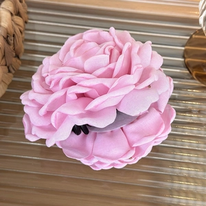 Detailed macro view of the multi-layered pink fabric rose petal hair claw clip