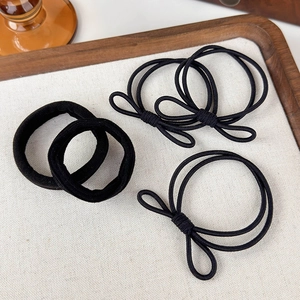 Dettaglio del set di cinque elastici neri con scrunchies in velluto e fiocchi chic
