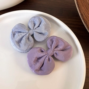 Vue détaillée de barrettes à nœuds en tissu bleu clair et violet sur un plateau