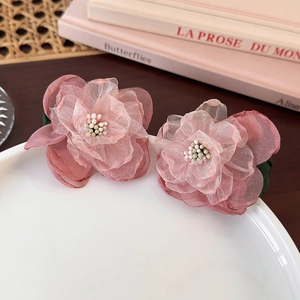 Close-up of pink layered mesh fabric flower hair clips with decorative beads