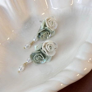 Vintage green and white ceramic rose stud earrings with pearls in a white ceramic tray