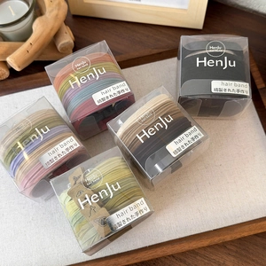 Five boxes of thick elastic hair ties in various colors on a natural wooden tray
