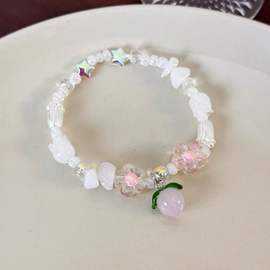 Vue détaillée d'un bracelet en perles fait main avec pendentif pêche et perles de fleurs