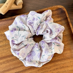 Detail of lavender floral scrunchie with layered mesh texture on wooden tray