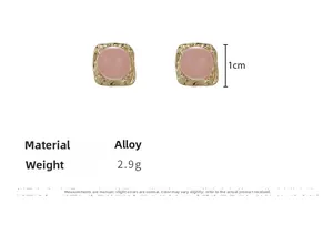 Detail view of 1cm square pink bead stud earrings with wavy gold alloy frames