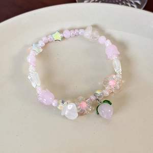 Détail du bracelet perlé avec pendentif pêche rose et perles de tulipes en acrylique