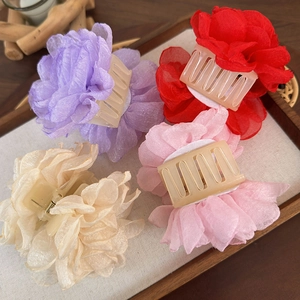 Vue détaillée de quatre pinces à cheveux en tulle coloré sur un plateau en bois rustique