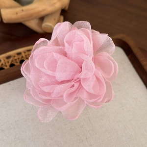 Détail d'une pince à cheveux fleur en organza rose avec pétales en mesh multicouches