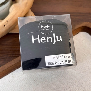 Close-up of black high-elastic plush hair bands in a branded transparent storage box