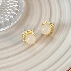 Detail view of pink translucent beads on gold irregular texture stud earrings