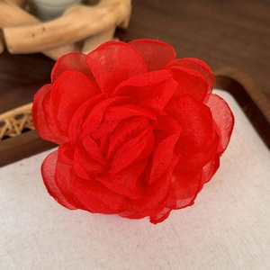 Gros plan sur une pince à cheveux rose rouge en soie avec couches de tulle translucide
