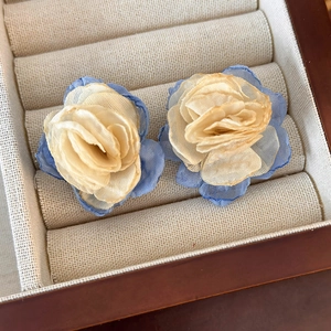 Detail of dual-layer mesh flower earrings in light beige and blue organza fabric