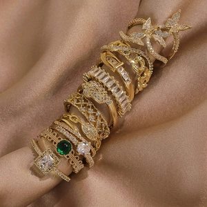 Détail de bagues dorées de luxe avec motifs papillon et pierres précieuses vert émeraude